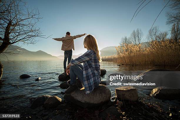 junge menschen am see in der natur-freiheit - couple see stock-fotos und bilder