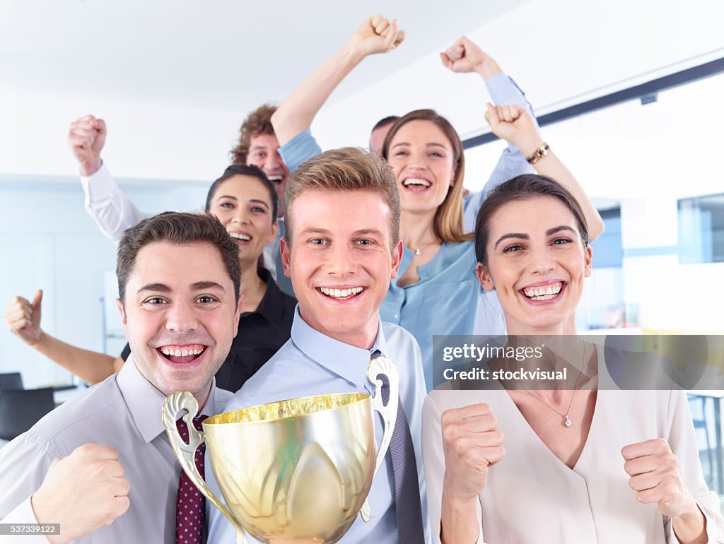 Successful businesspeople celebrating with the cup in hands