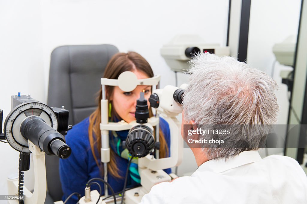 Young woman at the optometrist,doctor is checking her vision