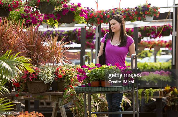 woman shopping for plants at a outdoor garden center. - tuincentrum stockfoto's en -beelden