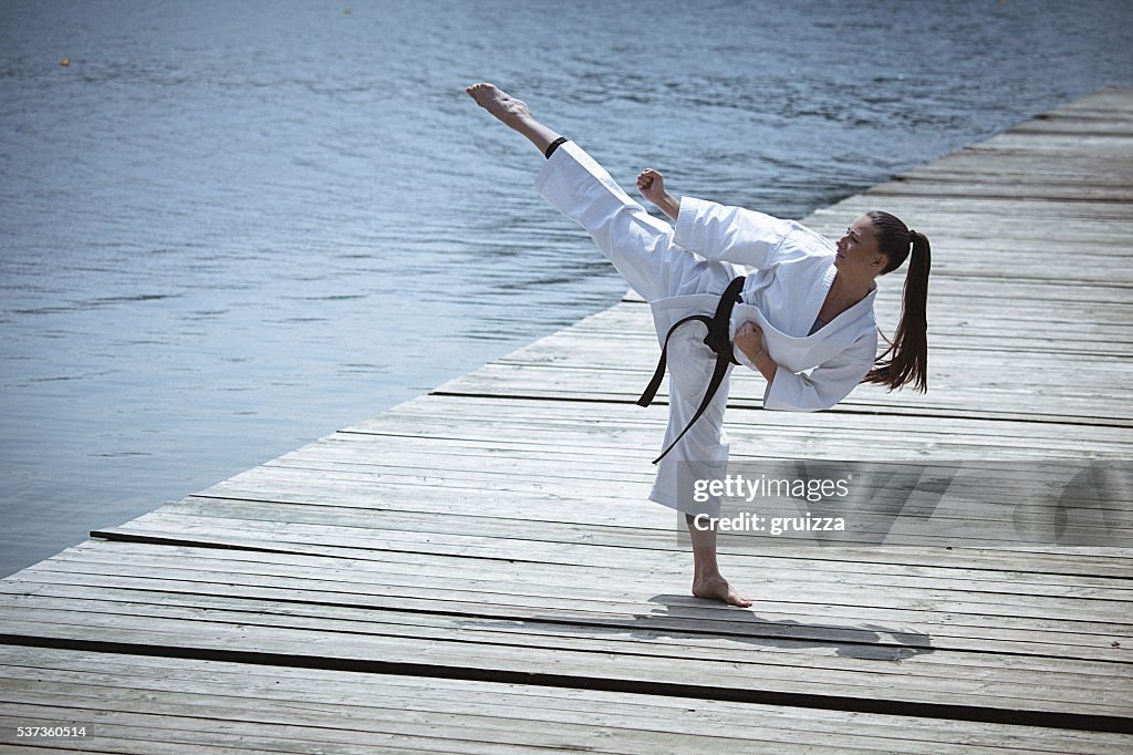 Junge Frau Übungen Karate im Freien
