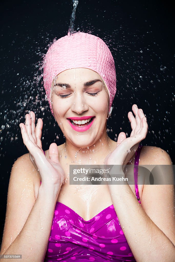 Laughing young woman being splashed with water.