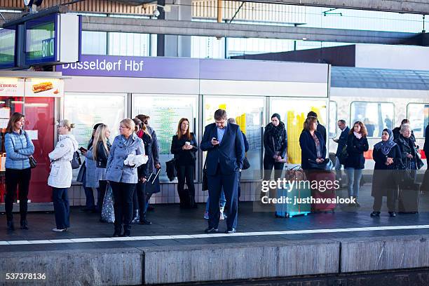 passagiere warten in bahnhof düsseldorf - deutsche bahn bahnhof stock-fotos und bilder