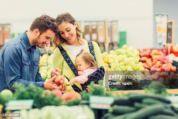 young family groceries shopping in local supermarket. - baby goods stock pictures, royalty-free photos & images