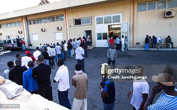 pozzallo, sicily: african migrants wait for breakfast at reception center - africa migration stock pictures, royalty-free photos & images