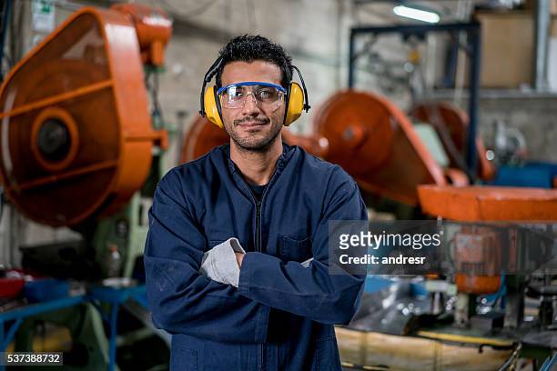 uomo che lavora in una fabbrica  - abbigliamento da lavoro foto e immagini stock