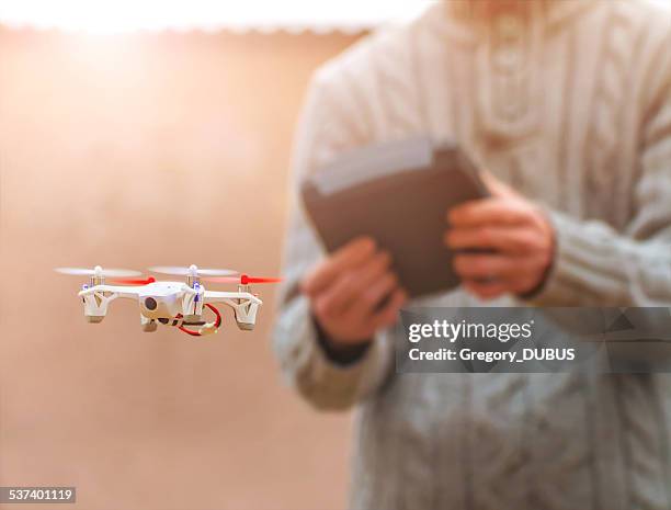 man flying small drone at sunlight - remote controlled plane stock pictures, royalty-free photos & images