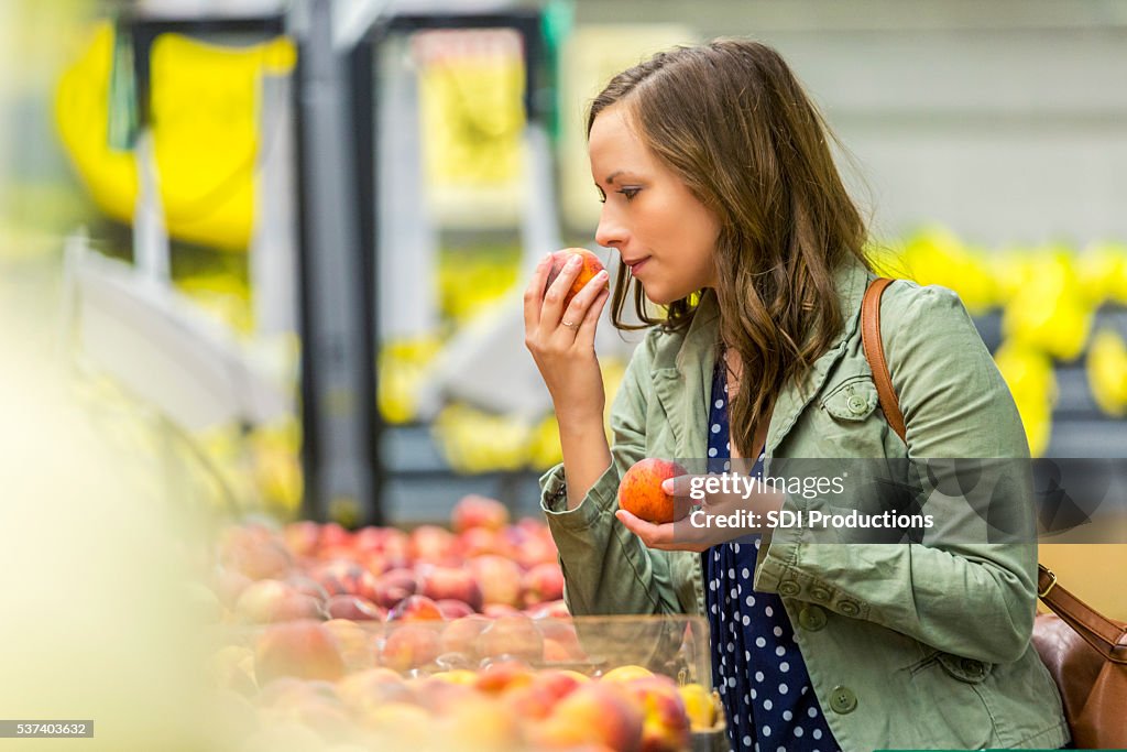 Pretty woman smelling fresh fruit