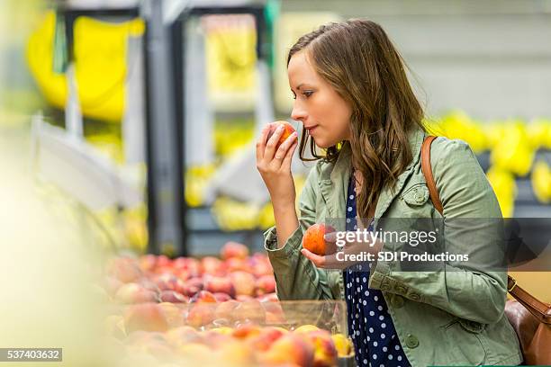 pretty woman smelling fresh fruit - 攤位 個照片及圖片檔