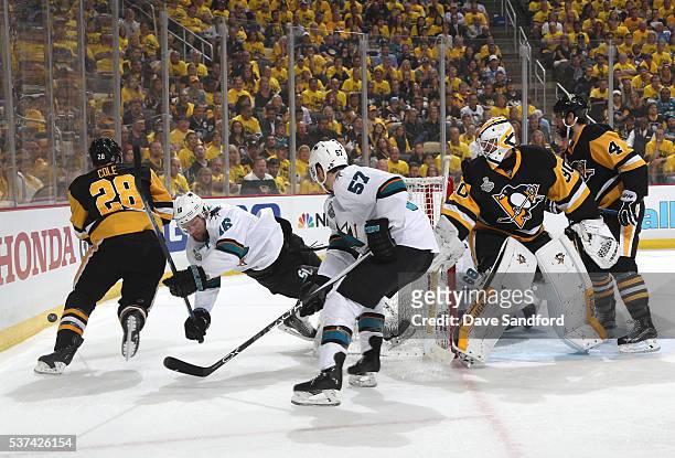Nick Spaling of the San Jose Sharks falls as Ian Cole of the Pittsburgh Penguins plays the puck along the end boards during the first period of Game...