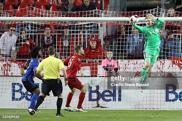 Toronto FC goalkeeper Clint Irwin makes a leaping save as the Toronto FC beats Montreal Impact 4-2 in the first leg of the Amway Canadian...