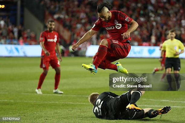 Mo Babouli leaps over Eric Kronberg as the Toronto FC beats Montreal Impact 4-2 in the first leg of the Amway Canadian Championship at BMO Field in...