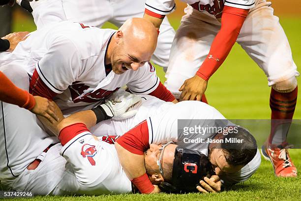 Chris Gimenez and Jason Kipnis celebrate with Yan Gomes of the Cleveland Indians after Gomes hit a walk-off RBI single in the eleventh inning to...