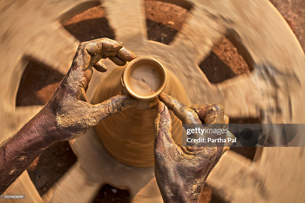 A potter is making daily use earthen pots