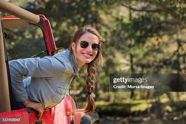 smiling young woman leaning out of jeep - off road vehicle imagens e fotografias de stock