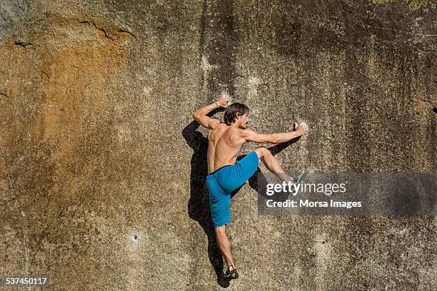 shirtless man climbing on rock - rock climbing stock pictures, royalty-free photos & images