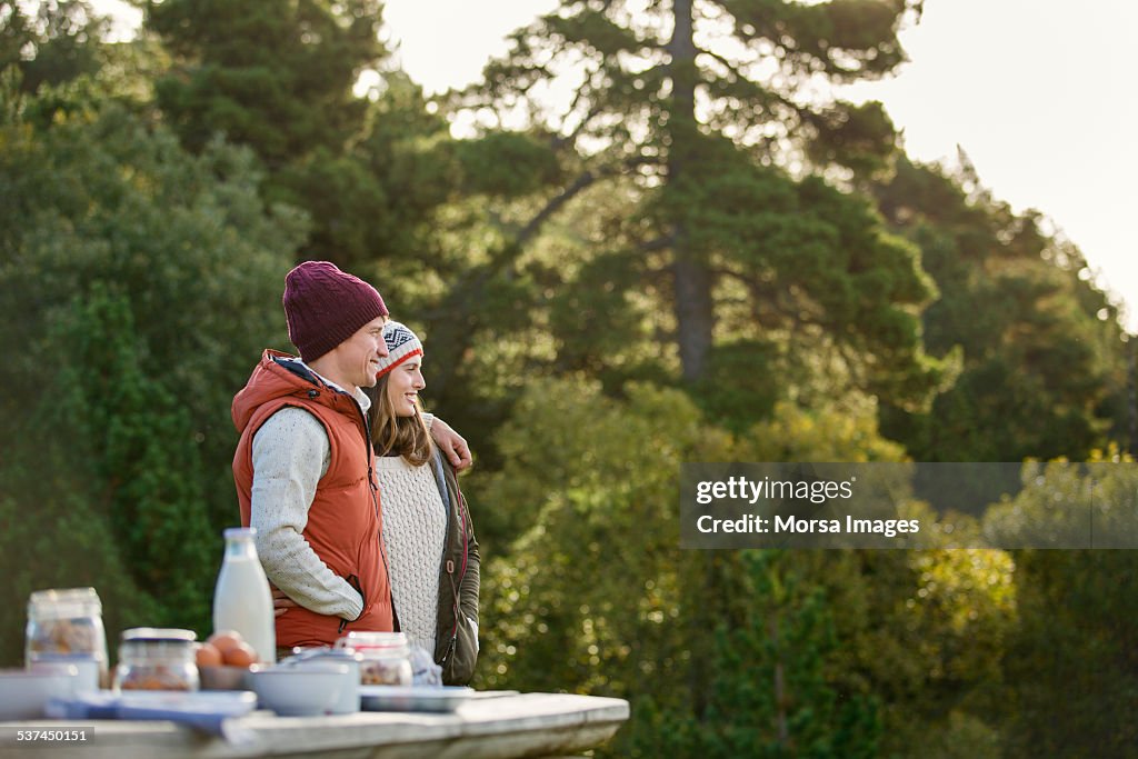 Loving young couple standing by picnic table