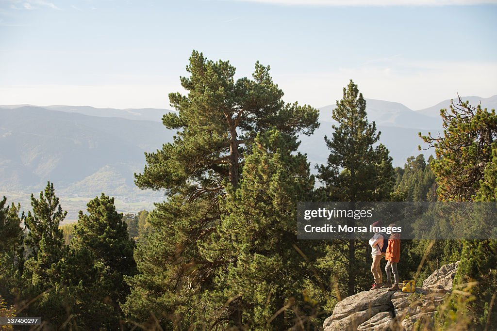 Male friends standing on rock