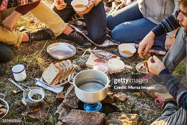 friends preparing breakfast at campsite - kochen stock-fotos und bilder