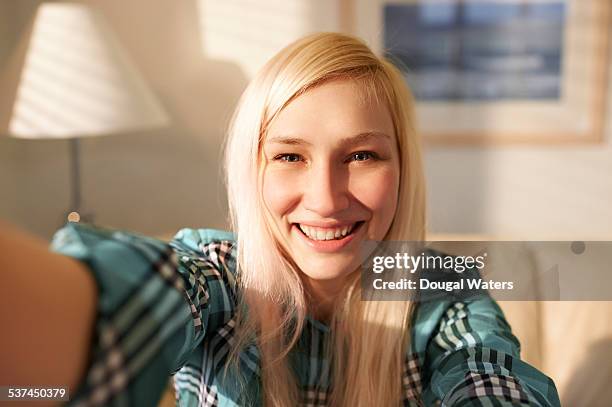 woman taking self portrait at home. - blonde woman selfie foto e immagini stock