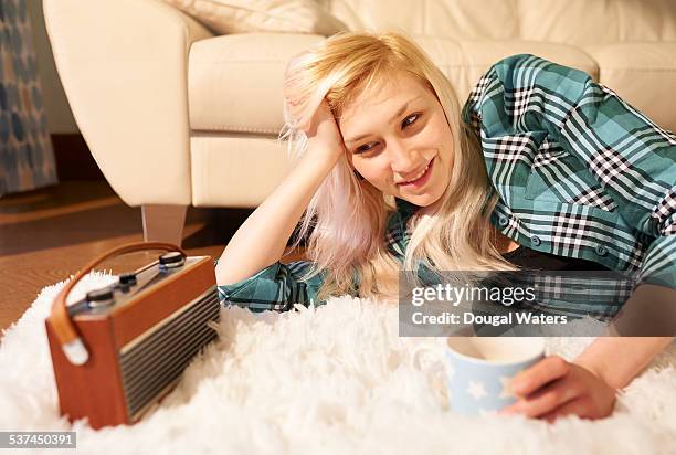 woman listening to radio at home with hot drink. - radio stock pictures, royalty-free photos & images