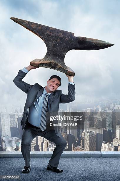 businessman lifting anvil over his head - anvil stock pictures, royalty-free photos & images