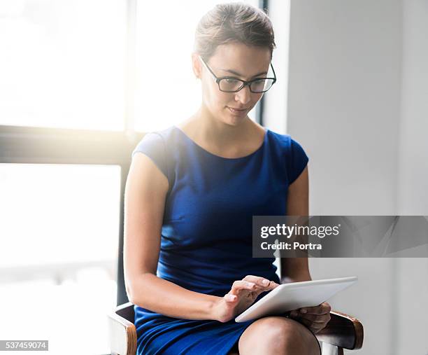 young businesswoman using digital tablet in office - blue dress stock pictures, royalty-free photos & images