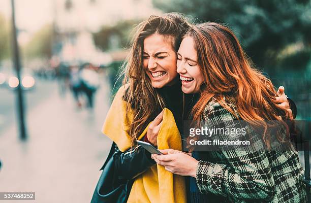 sms in paris - freundinnen lachen stock-fotos und bilder