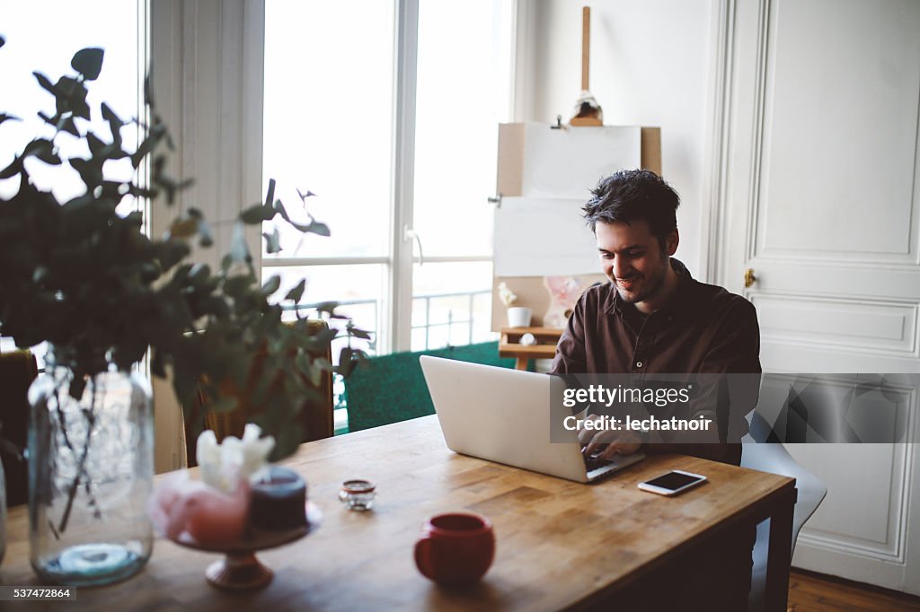 Jeune homme travaillant à la maison