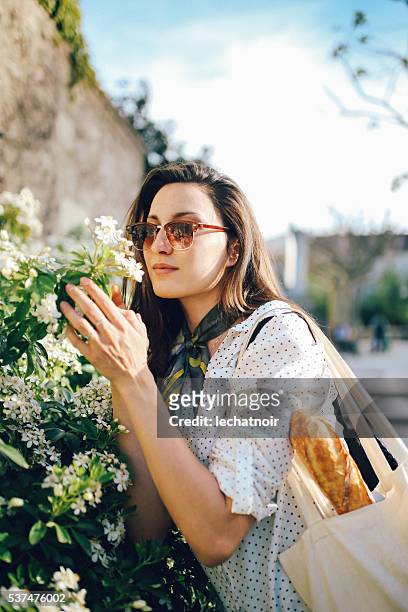 jeune femme appréciant des fleurs paris - tote bags photos et images de collection