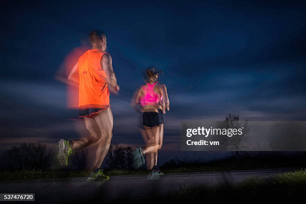 running on the road at dusk - multiple exposure running stock pictures, royalty-free photos & images