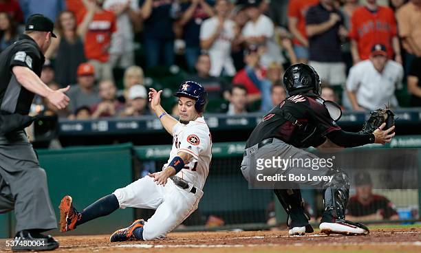 Jose Altuve of the Houston Astros scores in the fifth inning as slides around the tag attempt by Chris Herrmann of the Arizona Diamondbacks at Minute...