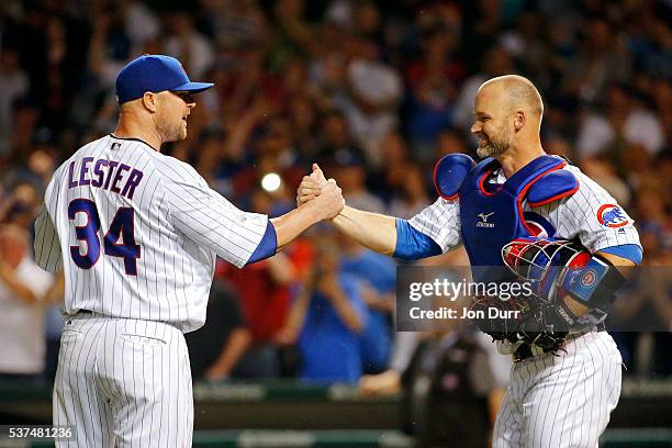 David Ross of the Chicago Cubs congratulates Jon Lester for pitching a complete game for the win against the Los Angeles Dodgers at Wrigley Field on...