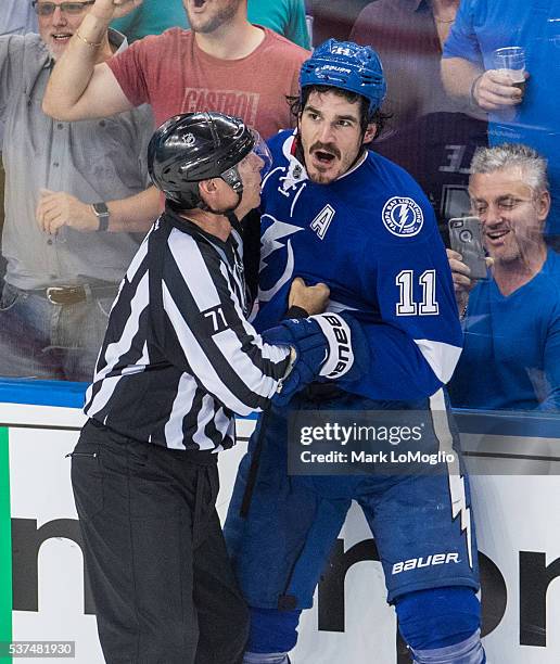 Brian Boyle of the Tampa Bay Lightning is held back against the Pittsburgh Penguins by linesman Brad Kovachik during Game Four of the Eastern...