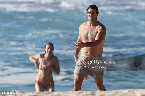 Former NRL player, Andrew Johns displays his surfing skills while on a beach outing with a female friend on May 24, 2016 in Sydney, Australia.