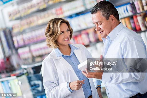 man at the drugstore asking pharmacist for advice - pharmacist and patient stock pictures, royalty-free photos & images