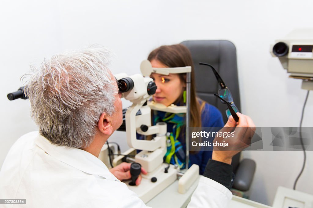 Young woman at the optometrist,doctor is checking her vision