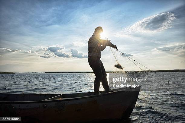 alter fischer auf seinem boot - commercial fishing net stock-fotos und bilder