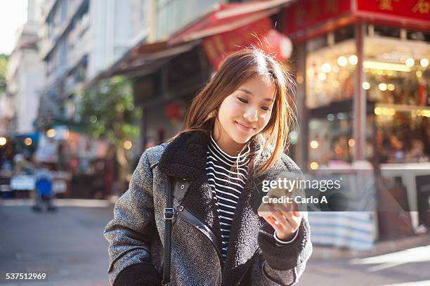 young woman at mobile phone - woman texting fotografías e imágenes de stock