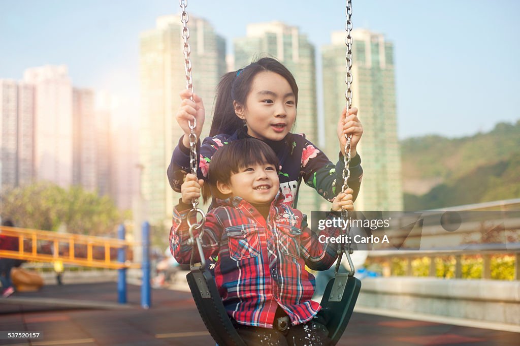 Brother and sister on swing