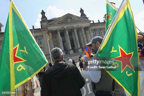 Two men carrying flags of the Kurdish YPG militias join a gathering to demand the recognition of the Armenian genocide outside the Reichstag, where...