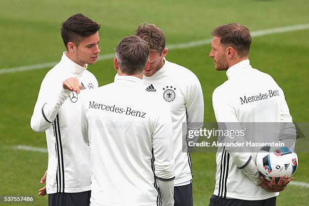 Julian Weigl of Germany talks to his team mates Bastian Schweinsteiger , Andre Schuerrle and Benedikt Hoewedes during a training session at stadio...