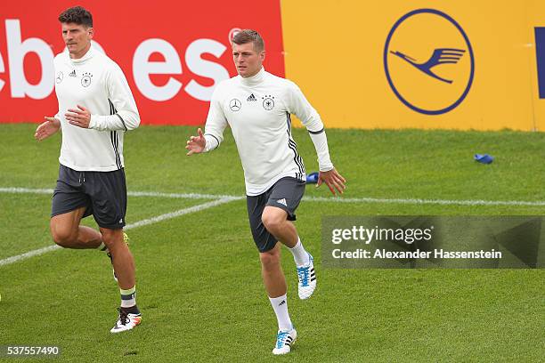 Toni Kroos of Germany warms up with his team mate Mario Gomez during a training session at stadio communale on day 10 of the German national team...