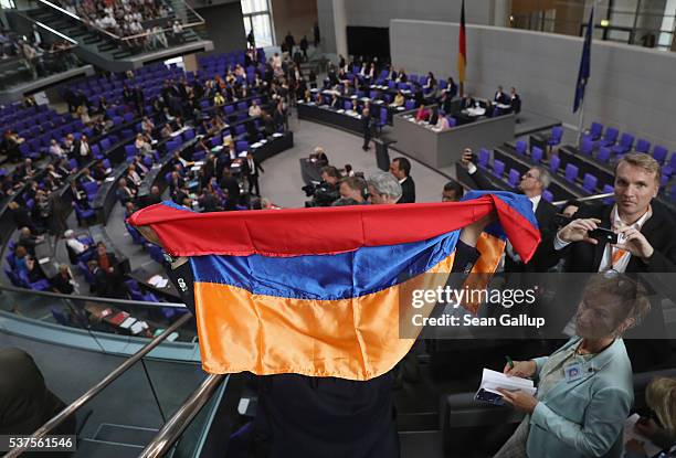 Visitor holds up an Armenian flag after parliamentarians approved with a show of hands a resolution to recognize the 1915 Armenian genocide on June...