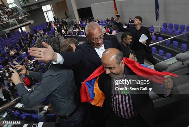 Visitor who had help up an Armenian flag after parliamentarians approved a resolution to recognize the 1915 Armenian genocide is escorted out of the...