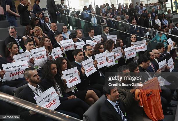 Visitors hold up signs that read: "Thank you" after parliamentarians approved a resolution at the Bundestag to recognize the 1915 Armenian genocide...