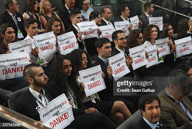 Visitors hold up signs that read: "Thank you" after parliamentarians approved a resolution at the Bundestag to recognize the 1915 Armenian genocide...