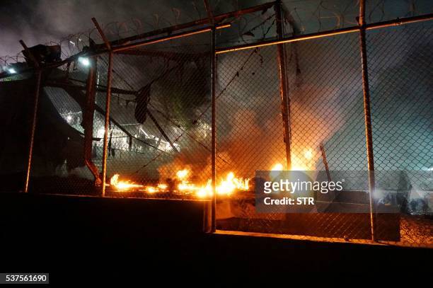 Fire burns at the Moria migrant detention camp, on the island of Lesbos, following clashes between migrants early on June 2, 2016. Over a dozen...