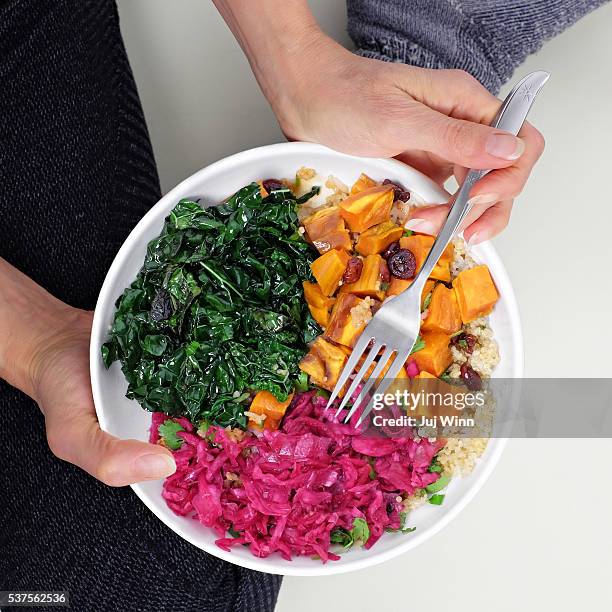 overhead view of woman eating - buddha bowl stock-fotos und bilder