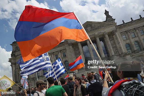 Activists hold up Armenian and Greek flags outside the Reichstag after parliamentarians at the Bundestag approved a resolution to recognize the 1915...